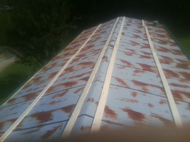 Rusted metal roof panels with new wood purlins before replacement — Storm Damage Roof Repair in Melstone by Roofing Brothers