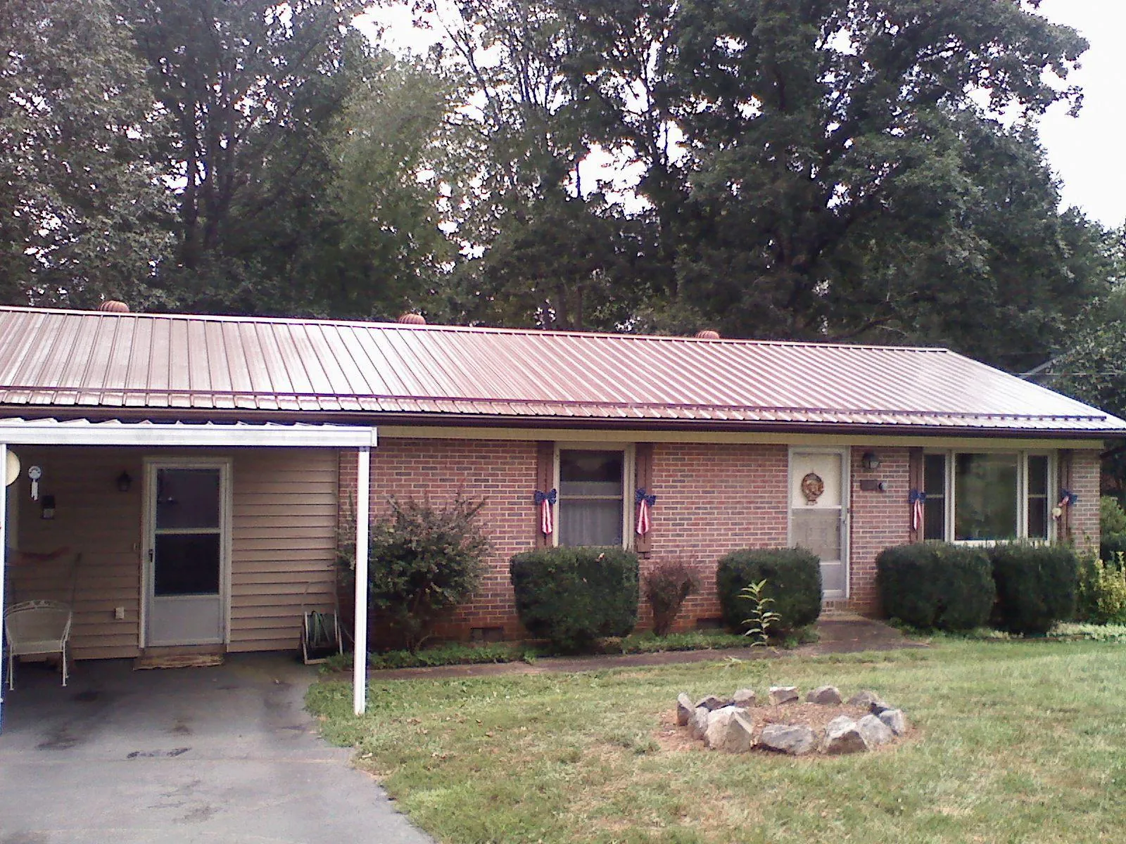 Bronze metal roof and carport on a brick ranch home — Roof Repair work by our crew in Melstone